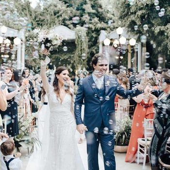 Noivo e noiva saindo da cerimônia de casamento.